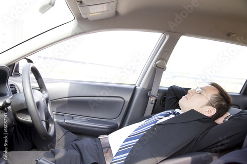 Photo: 車内で仮眠をとるビジネスマン 車内で仮眠をとるビジネスマン