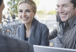 Couple and man on outdoor patio with laptop