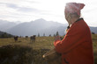 Woman holding butter tub, cow in background