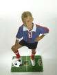 Boy (8-11) with foot on football, hand on hips