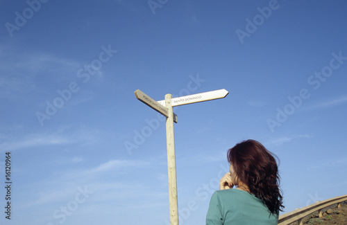 Photo: Spain, La Palma, woman standing in front of dirction sign Spain, La Palma, woman standing in front of dirction sign