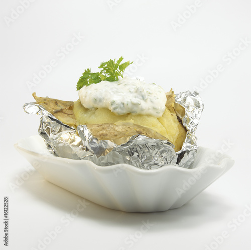 Photo: Baked potato with curd cheese in foil, close-up Baked potato with curd cheese in foil, close-up