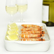 Prawns with lemon slices on crushed ice and white wine, close-up