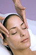 Young woman receiving facial massage, eyes closed, close-up