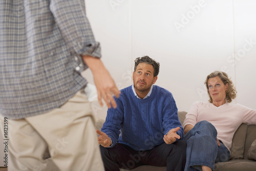 Photo: Parents discussing with son, rear view Parents discussing with son, rear view