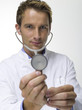 Male doctor holding stethoscope, close-up, portrait