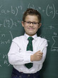 Boy (10-11) leaning against blackboard, smiling, portrait, close-up