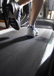 Woman's legs on a treadmill in a gym