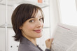 Businesswoman reading newspaper, portrait