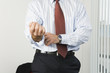 View of a businessman rolling up sleeves.
