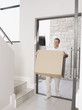 Man moving large box into new home