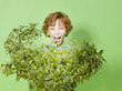 Young hiding behind green bush
