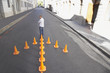 Man standing with arrow-shaped traffic cones in roadway