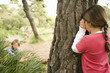 Children playing hide and seek in forest