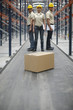 Cardboard box and workers in warehouse