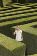 Young woman lost in hedge maze