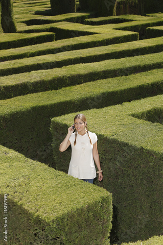 Foto: Young woman lost in hedge maze Young woman lost in hedge maze
