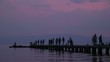 Silhouettes of people on a stone pier Silhouettes of people on a stone pier