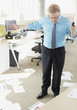 Businessman looking at papers on floor