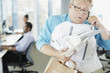 Businessman talking on phone holding paperwork and coffee