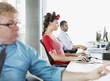 Businesswoman working and wearing curlers at desk