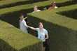 Young adults holding hands in a hedge maze