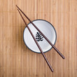 Photo: Chopsticks with ceramic bowl on bamboo mat Chopsticks with ceramic bowl on bamboo mat