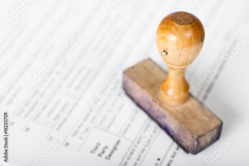 Photo: Old and very used wooden Rubber Stamp on form Old and very used wooden Rubber Stamp on form