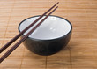 Photo: Chopsticks with ceramic bowl on bamboo mat Chopsticks with ceramic bowl on bamboo mat