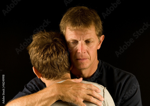 Photo: Father cries as he hugs his son Father cries as he hugs his son