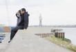Three young men in hoodies sitting on wall