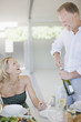 Man opening wine bottle for wife