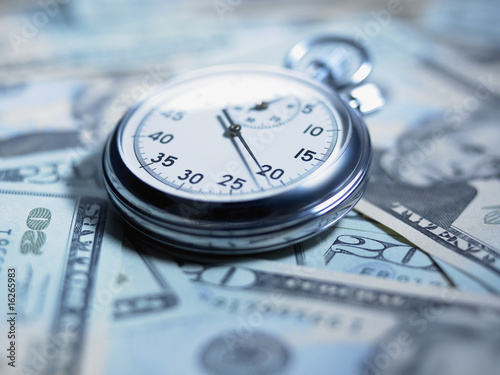 Photo: Close up of stopwatch on 20 dollar bills Close up of stopwatch on 20 dollar bills