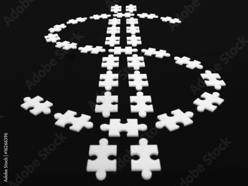Photo: Puzzle pieces in shape of dollar sign Puzzle pieces in shape of dollar sign