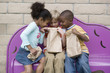 Children looking in friend?s lunch bag at recess