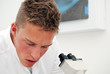 Young male lab technician looks at results