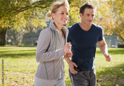 Photo: Couple jogging in park in autumn Couple jogging in park in autumn