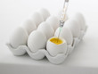 Close up of syringe injecting yolk of egg
