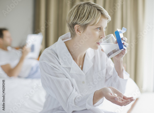 Photo: Sick woman taking antacid Sick woman taking antacid