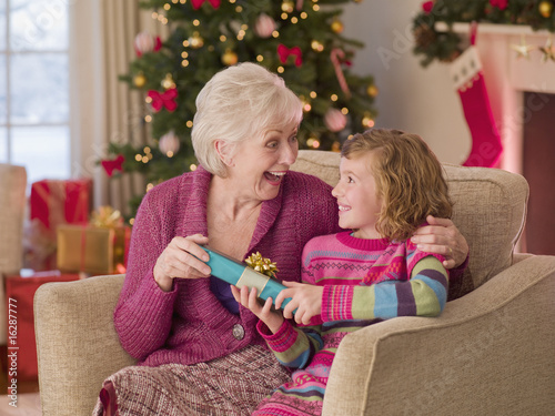 Photo: Girl giving grandmother Christmas gift Girl giving grandmother Christmas gift
