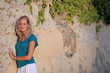 Very pretty young woman standing against the wall