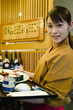 料理を運ぶ女性店員