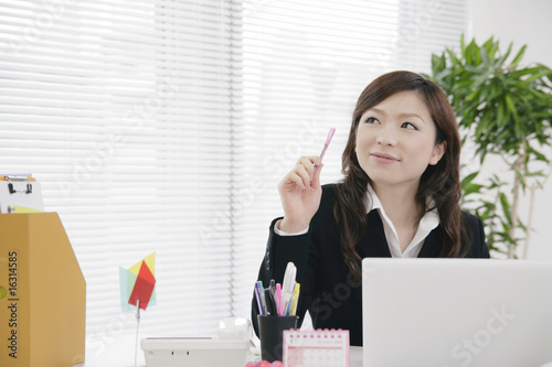 デスクでアイデアを思い付く女性