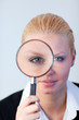 Serious Business woman looking through a magnifying Glass Serious Business woman looking through a magnifying Glass