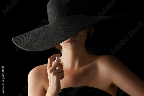 Photo: elegant woman applying perfume on her body elegant woman applying perfume on her body