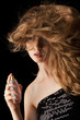 woman with flipping hair applying perfume on her body woman with flipping hair applying perfume on her body