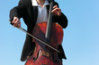 close-up musician plays violoncello against sky close-up musician plays violoncello against sky