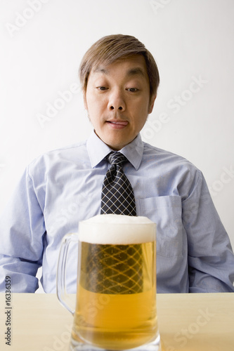 Foto: ビールジョッキを眺める中年男性 ビールジョッキを眺める中年男性