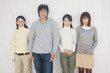 白い壁の前に立つ男女４人