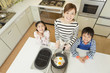 ベーコンエッグを作る母親と子供２人